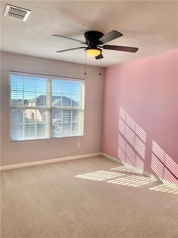 a view of a livingroom with a ceiling fan and window