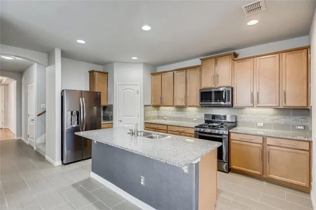 a kitchen with stainless steel appliances granite countertop a refrigerator stove microwave and sink