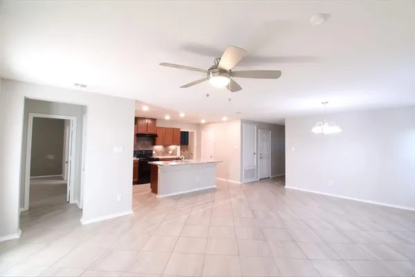 a kitchen with kitchen island granite countertop a stove top oven a sink and a refrigerator