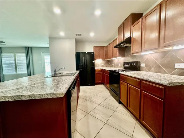 a kitchen with granite countertop stainless steel appliances and wooden cabinets