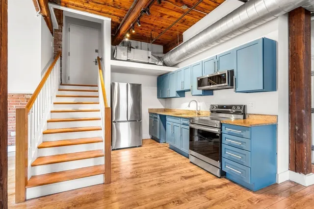 a kitchen with stainless steel appliances kitchen island granite countertop a refrigerator and a stove top oven