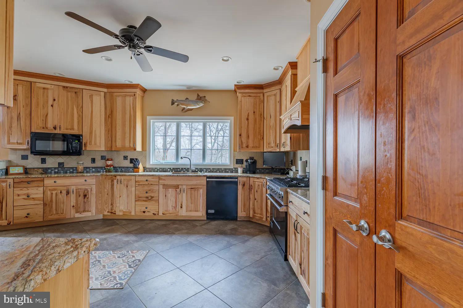 33487 Galena Sassafras Road Galena, MD 21635 - Photo 11 of 59 a large kitchen with granite countertop a stove top oven a sink a window and stainless steel appliances
