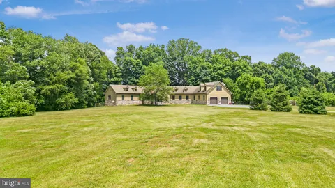 a view of a white house with a yard covered in snow