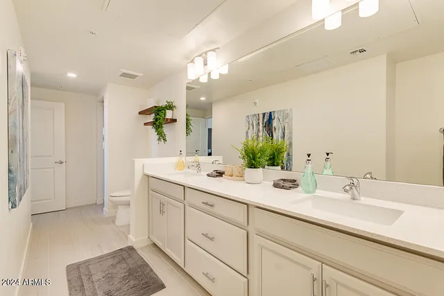 a bathroom with a double vanity sink mirror and next to a window