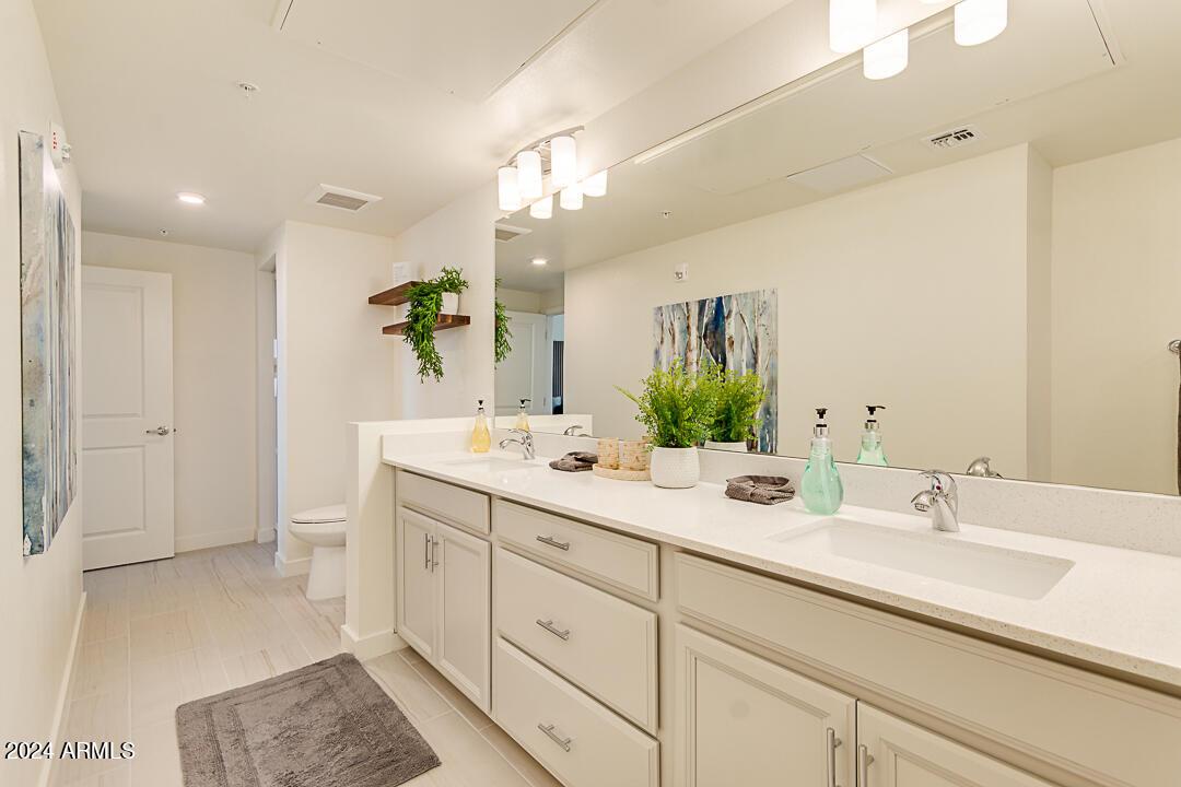 2511 West Queen Creek Road, Unit 416 Chandler, AZ 85248 - Photo 19 of 30 a bathroom with a double vanity sink mirror and next to a window