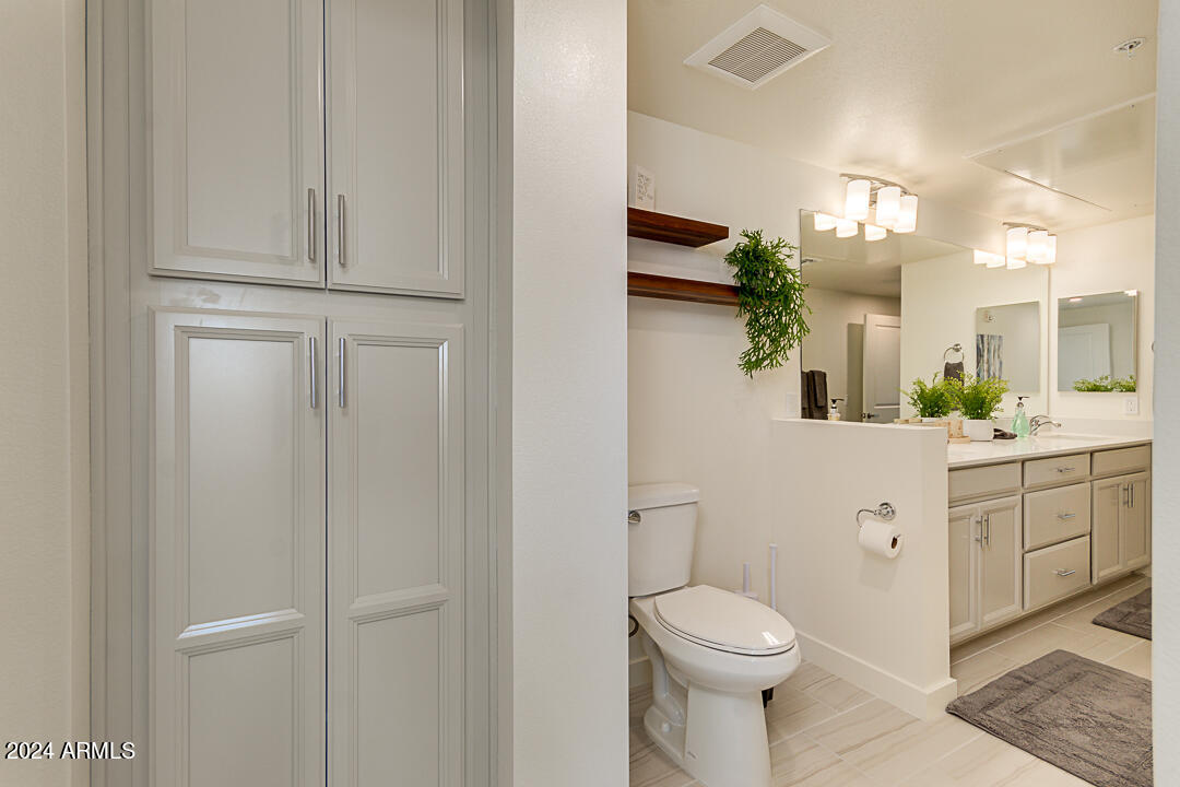 2511 West Queen Creek Road, Unit 416 Chandler, AZ 85248 - Photo 21 of 30 a bathroom with a white toilet sink and vanity