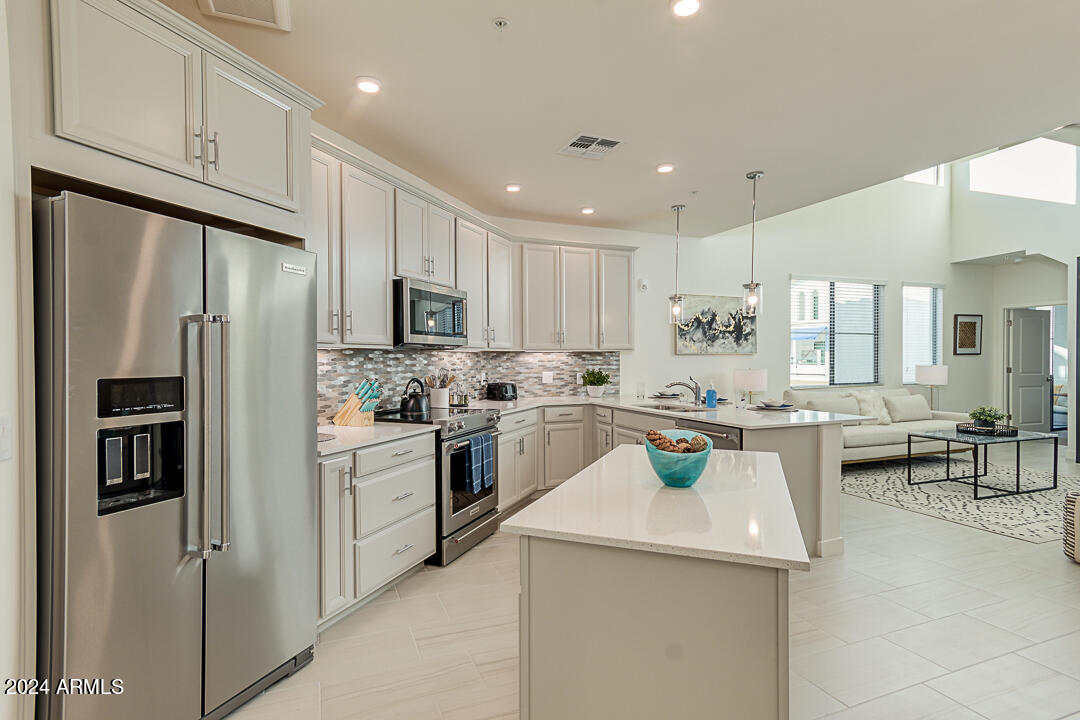 2511 West Queen Creek Road, Unit 416 Chandler, AZ 85248 - Photo 7 of 30 a kitchen with a sink stainless steel appliances and white cabinets
