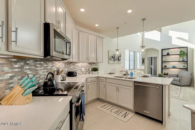 a kitchen with stainless steel appliances a sink stove and cabinets