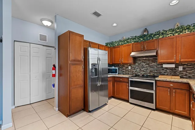 a kitchen with stainless steel appliances granite countertop a refrigerator and a sink