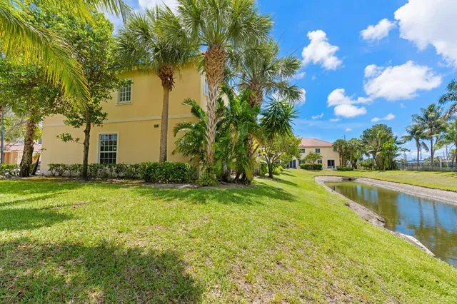 a view of a fountain in front of a house with a big yard
