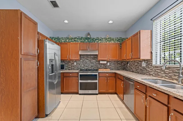 a kitchen with stainless steel appliances granite countertop a refrigerator and a sink