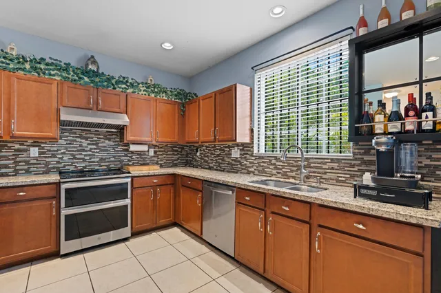 a kitchen with stainless steel appliances granite countertop a sink and a stove