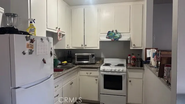 a kitchen with stainless steel appliances white cabinets and a refrigerator