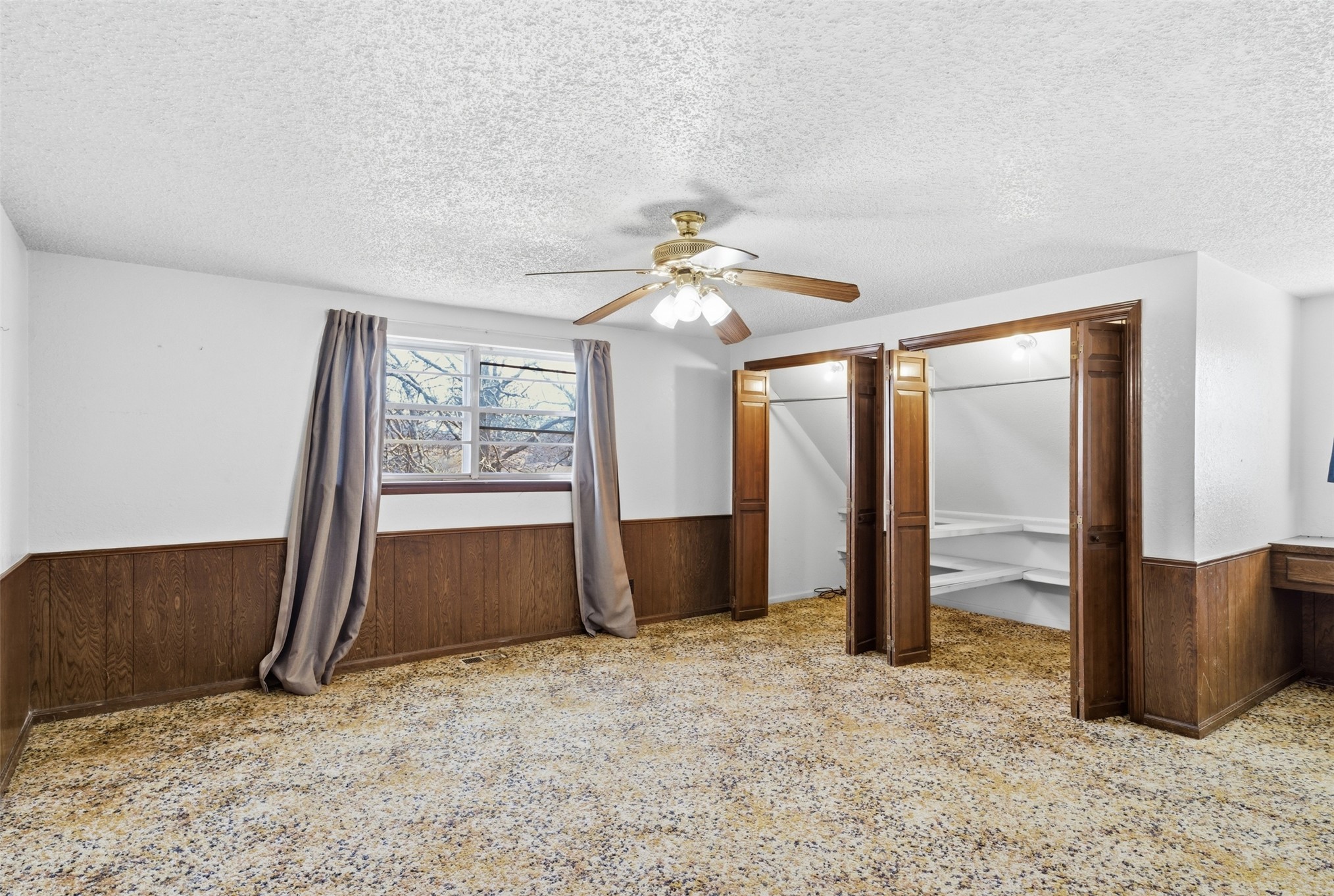 17875 East 589 Road Inola, OK 74036 - Photo 64 of 73 Window with natural light, wood-finish wall paneling, ceiling fan with light fixture, built-in shelving in closet, built-in desk