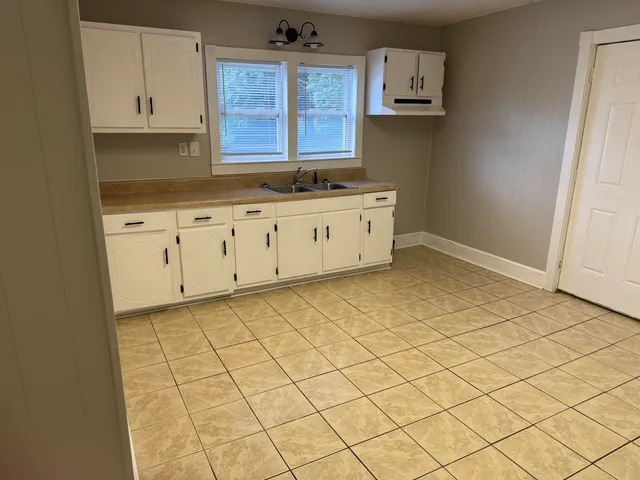 a kitchen with granite countertop white cabinets and stainless steel appliances