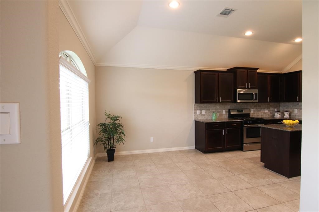 6719 Rambling Manor Court Richmond, TX 77469 - Photo 5 of 26 a kitchen with stainless steel appliances granite countertop a stove a sink and a refrigerator