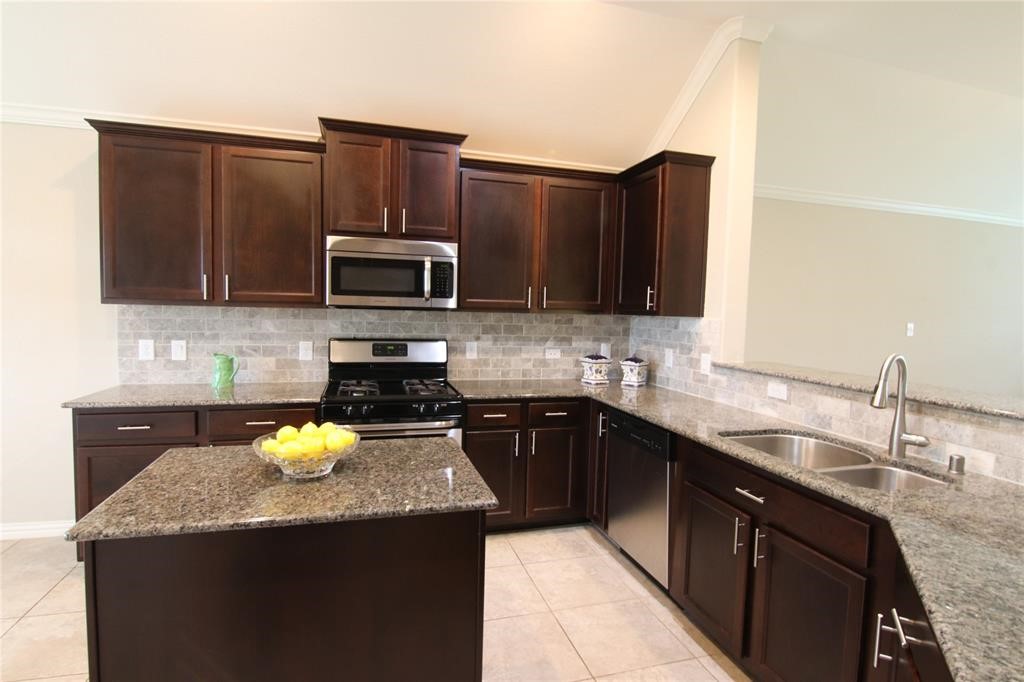 6719 Rambling Manor Court Richmond, TX 77469 - Photo 9 of 26 a kitchen with granite countertop stainless steel appliances a stove sink and cabinets