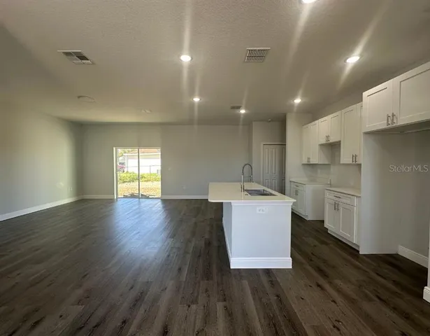 a kitchen with a sink wooden floor and stainless steel appliances