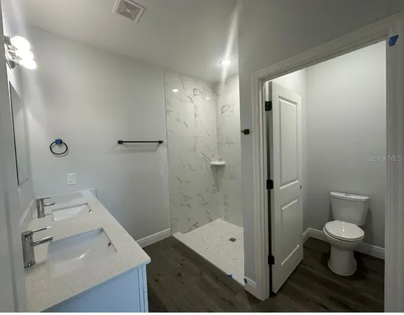 a bathroom with a sink a toilet and shower