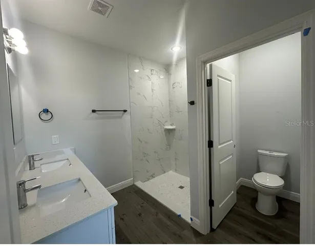 a bathroom with a sink a toilet and shower