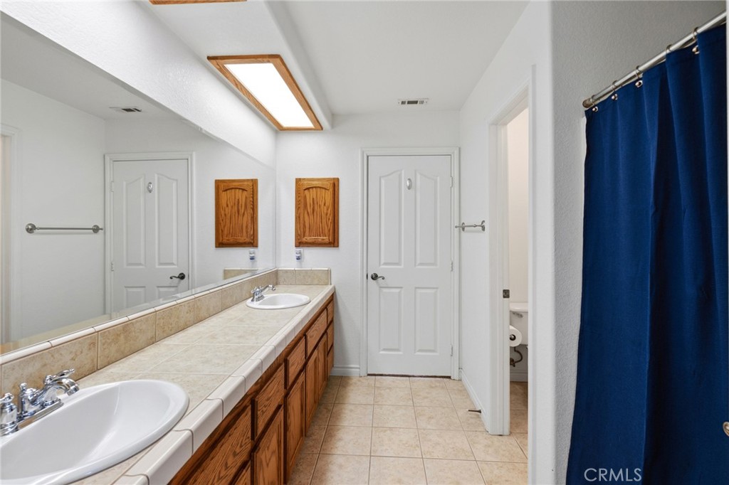 11025 El Esteban Road Phelan, CA 92371 - Photo 29 of 54 a bathroom with a granite countertop sink and a mirror