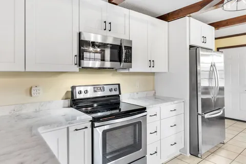 a kitchen with stainless steel appliances granite countertop a refrigerator and a sink