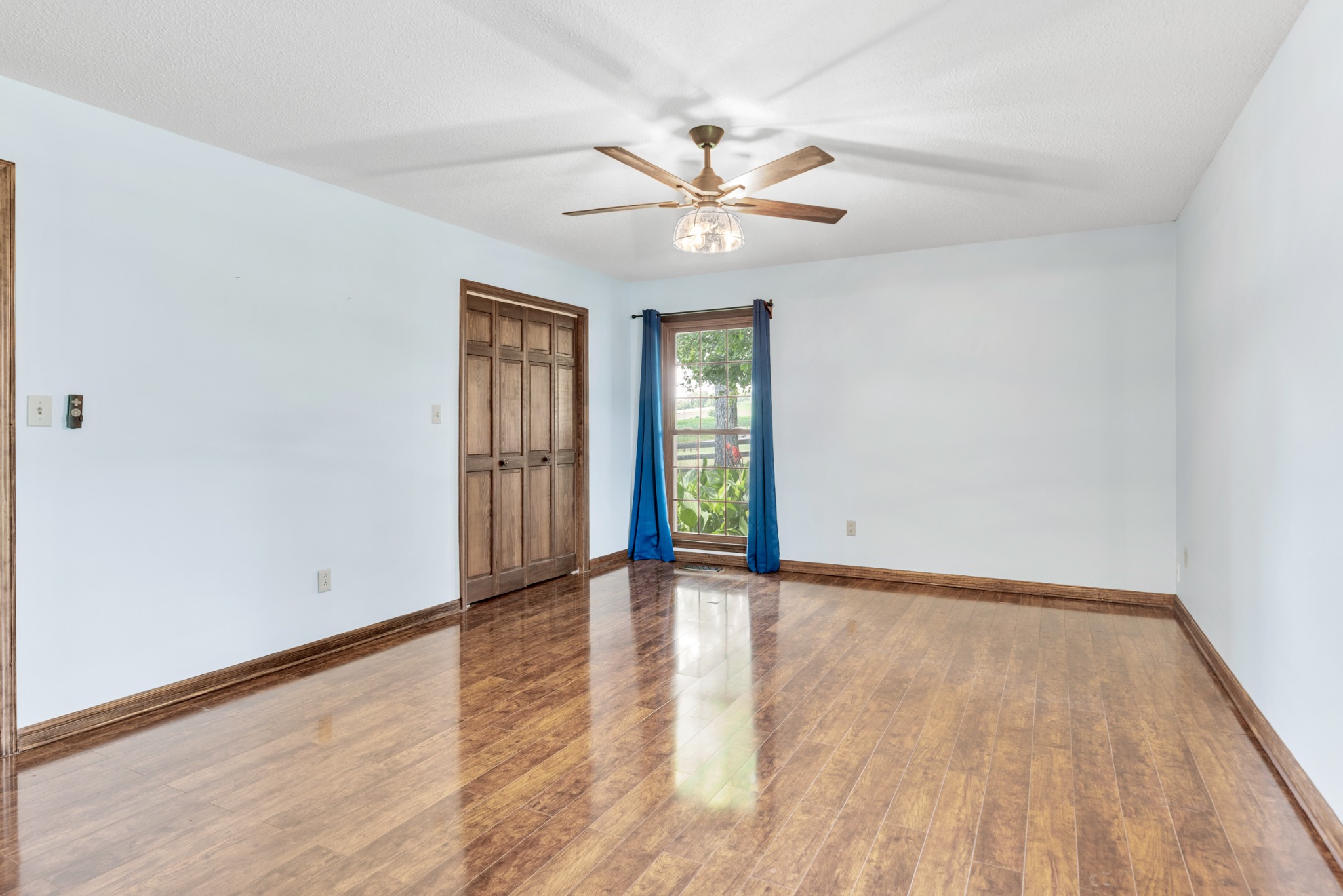 719 Waco Road Lynnville, TN 38472 - Photo 23 of 67 an empty room with wooden floor fan and windows