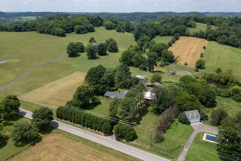 an aerial view of green landscape with trees houses and lake view