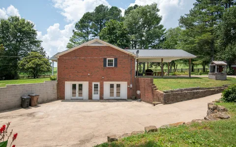 a front view of a house with a yard and trees