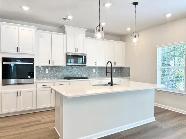 a kitchen with kitchen island granite countertop a sink a center island and cabinets