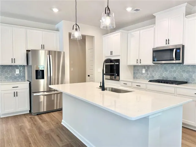 a kitchen with stainless steel appliances a refrigerator sink and microwave