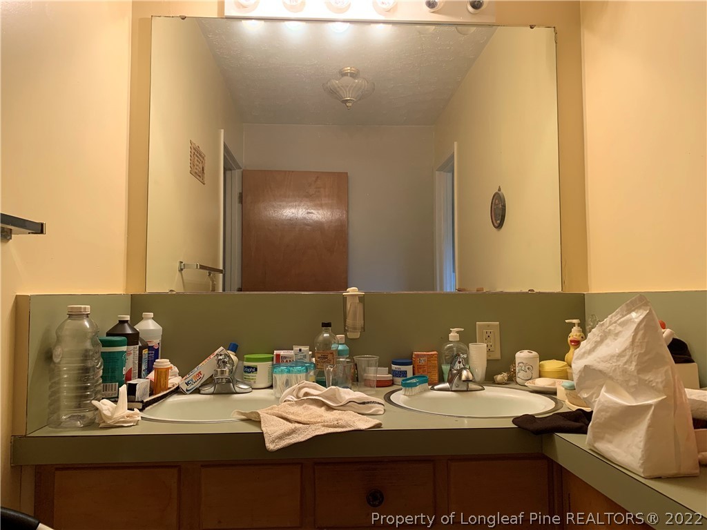 350 Horseshoe Road Aberdeen, NC 28315 - Photo 19 of 47 a bathroom with a sink and a mirror