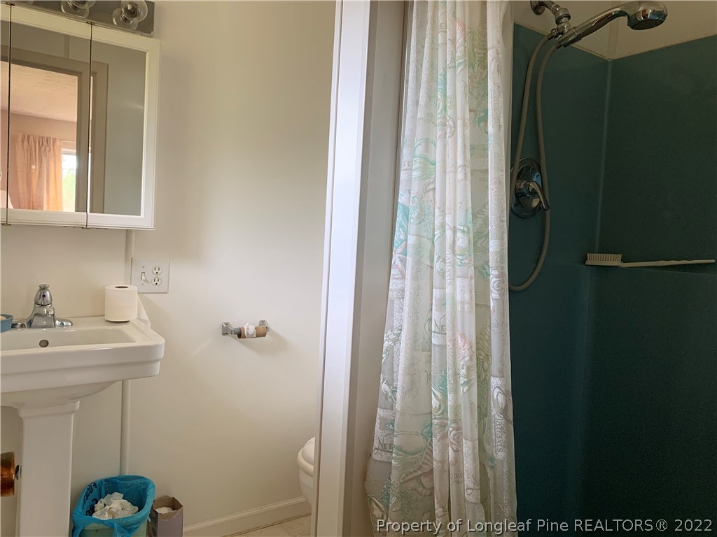 350 Horseshoe Road Aberdeen, NC 28315 - Photo 26 of 47 a bathroom with a sink a mirror and shower