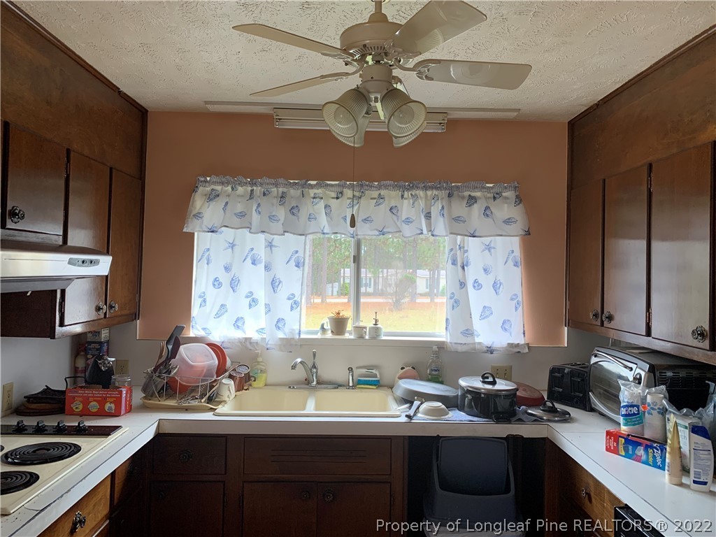 350 Horseshoe Road Aberdeen, NC 28315 - Photo 6 of 47 a kitchen with a sink a stove and cabinets