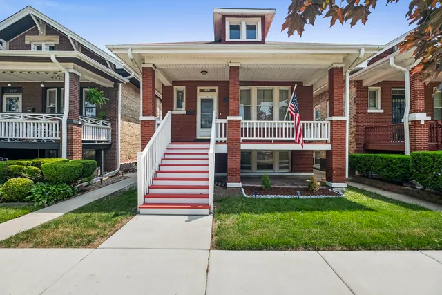 a front view of a house with a yard and potted plants