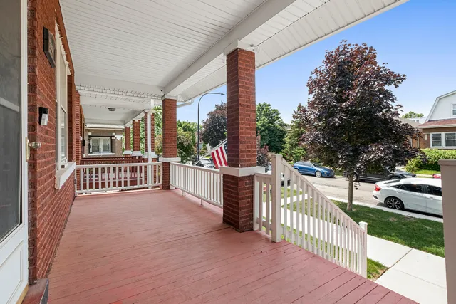 a view of a porch with wooden fence and trees