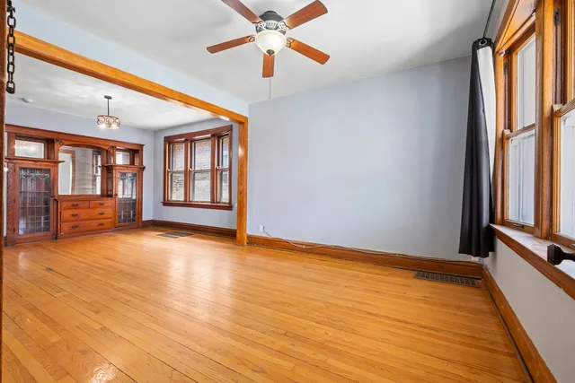 a view of an empty room with a window and wooden floor