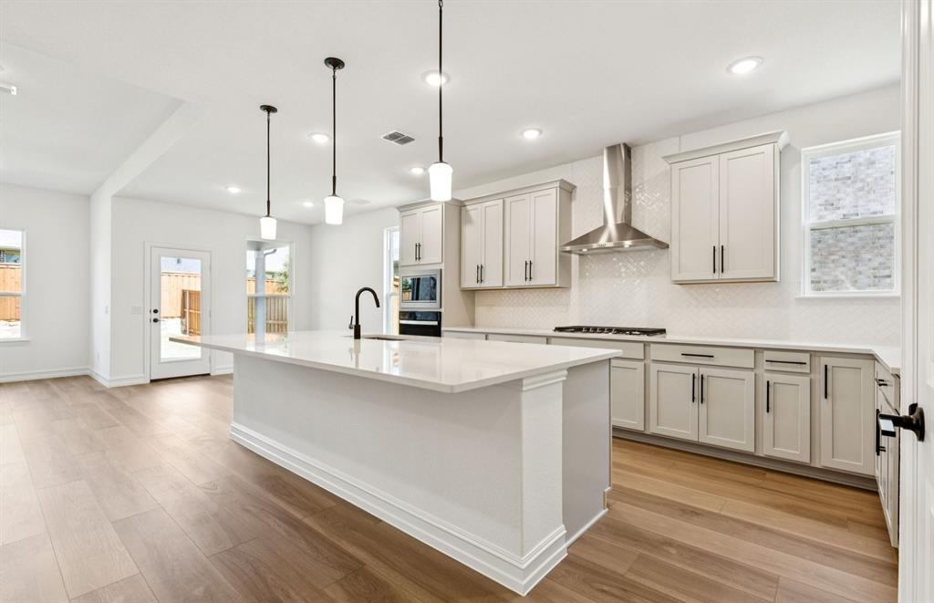 304 Brookhurst Road Little Elm, TX 75068 - Photo 2 of 22 a kitchen with stainless steel appliances sink refrigerator and wooden floor