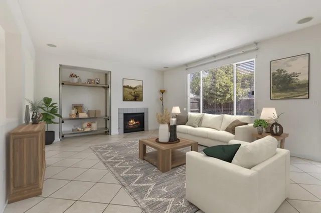 a living room with furniture a large window and a fireplace