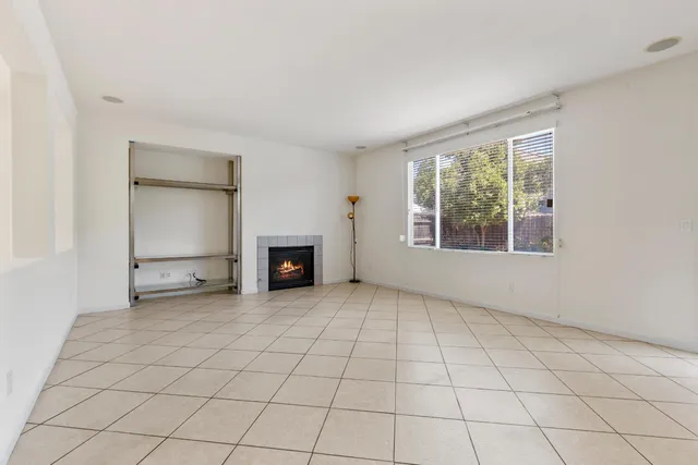 an empty room with windows and fireplace