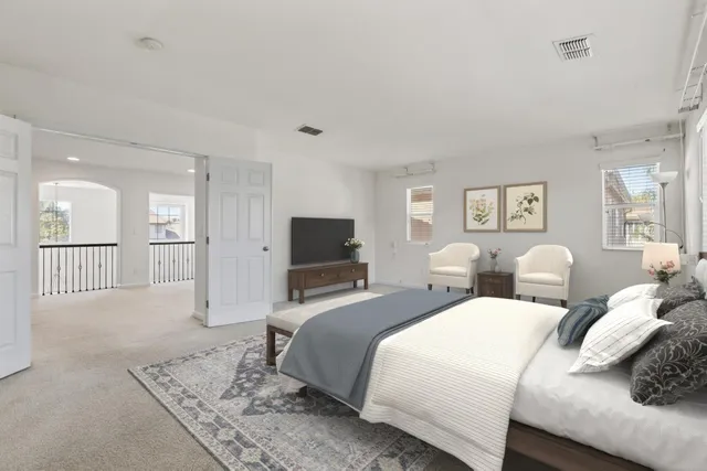 a spacious bedroom with two beds and a flat screen tv