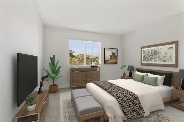 a bedroom with a large bed and a potted plant