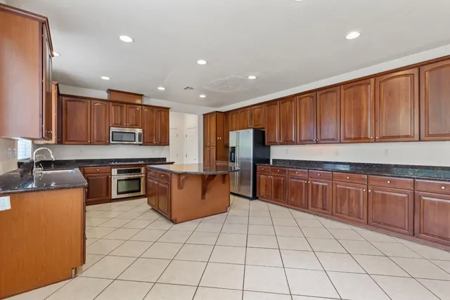 a kitchen with stainless steel appliances granite countertop a stove top oven a sink a counter top space and cabinets