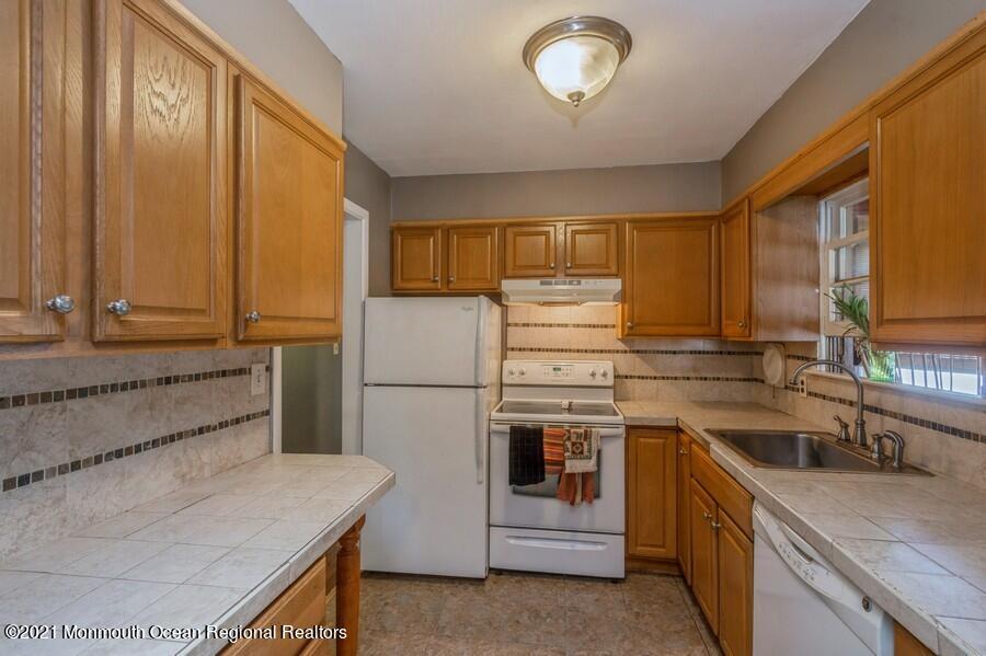 665 Aldrich Road Howell, NJ 07731 - Photo 7 of 23 a kitchen with a sink and a refrigerator