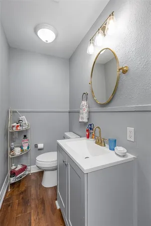 a bathroom with a toilet sink vanity and mirror