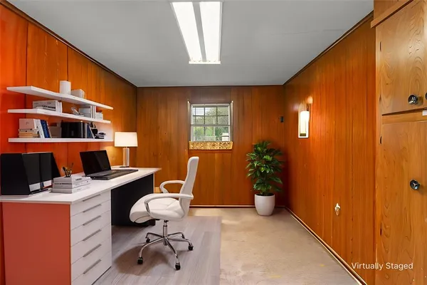 a view of a workspace with furniture and a window