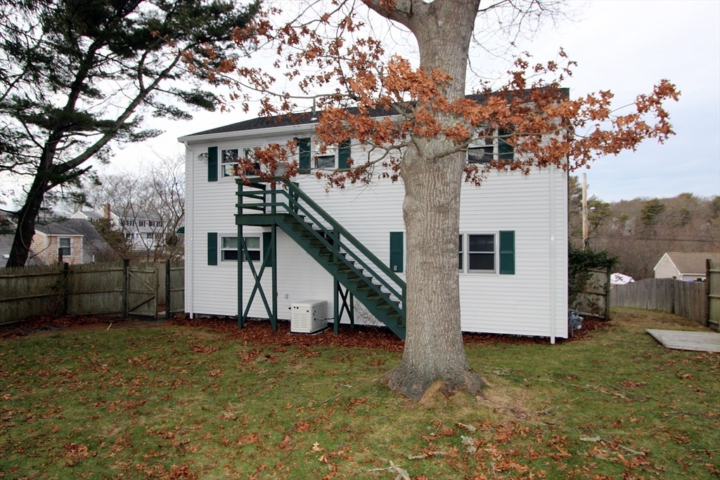 4 Van Bummel Road Bourne, MA 02532 - Photo 4 of 25 a view of a white house with a big yard and large tree