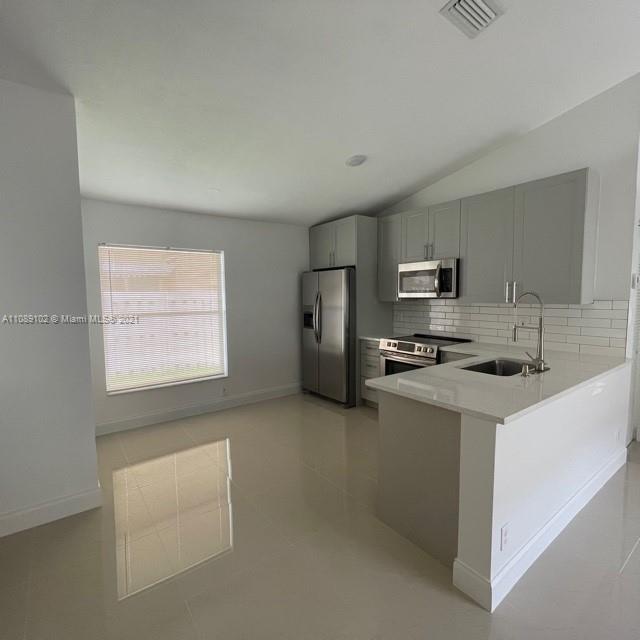 Silver Lakes Pembroke Pines, FL 33029 - Photo 5 of 19 a kitchen with stainless steel appliances a refrigerator a sink a stove top oven and white cabinets