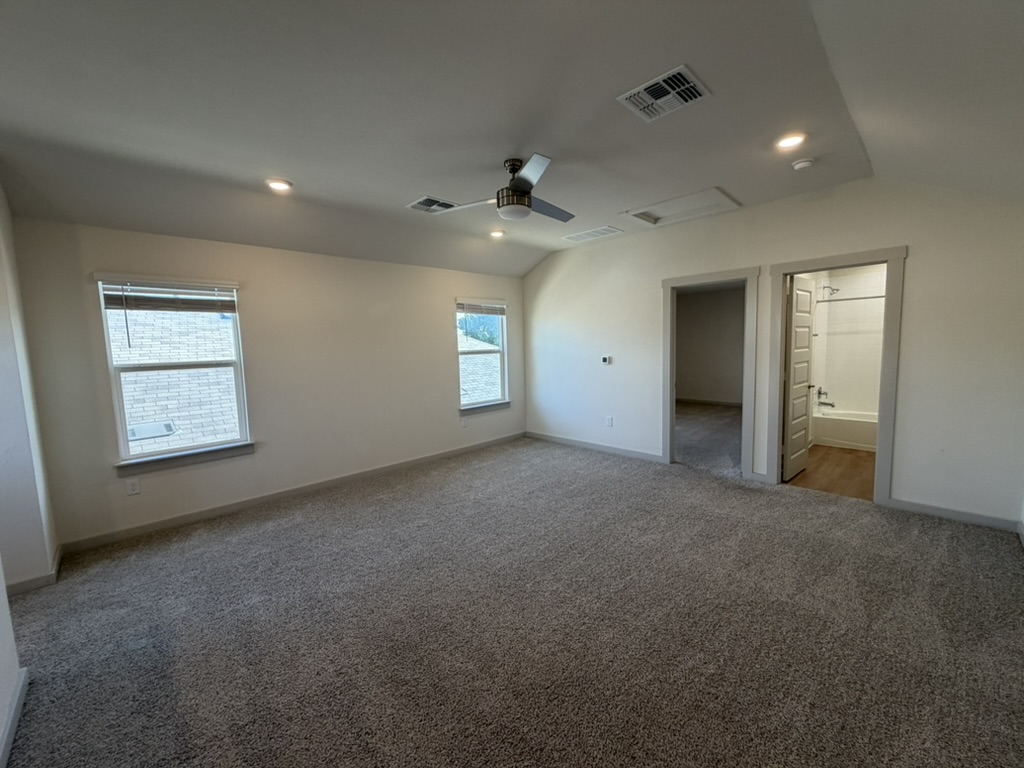 10708 Gonzales Ranger Pass Austin, TX 78754 - Photo 39 of 40 A spacious primary bedroom with a vaulted ceiling and direct access to a private bathroom.