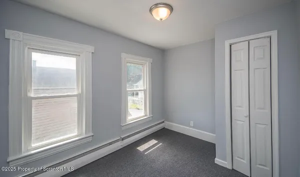 an empty room with windows and closet